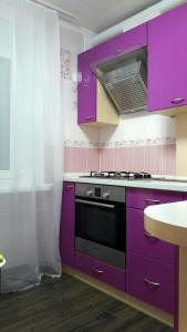 a kitchen with purple cabinets and a stove at Apartments in the Center of the city in Dnipro