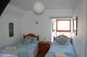 1 dormitorio con 2 camas y ventana en James John Hamilton House and backpacker hostel, en Fishguard
