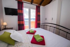 Schlafzimmer mit einem Bett mit roten und grünen Handtüchern in der Unterkunft Villa Jozini trudi in Lokva Rogoznica