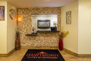 a living room with a brick wall at Hawthorn Suites by Wyndham St. Robert/Ft. Leonard Wood in Saint Robert