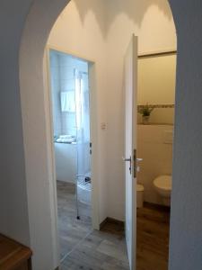 an open door to a bathroom with a toilet at Hotel Pension Lindenhof in Prien am Chiemsee