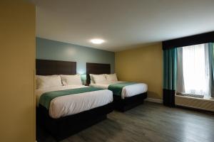 Hawthorn Extended Stay by Wyndham Saint Robert客房内的一张或多张床位