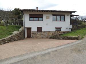 una casa bianca con un muro di pietra di Garai Etxea, casa adosada en la montaña a Arrankudiaga