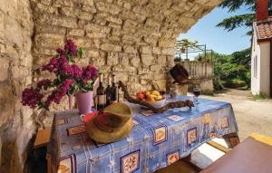 a table with a bowl of fruit and bottles of wine at Holiday Home Marica in Kastav