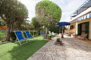 eine Terrasse mit blauen Gartenstühlen und einem Sonnenschirm in der Unterkunft Hotel Da Italo in Seccheto
