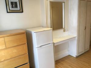 uma cozinha com um frigorífico branco e um espelho em Hyde Park Rooms & Apartments em Londres