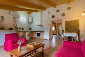 a living room with two red chairs and a table at Casa Contorna in Agullo
