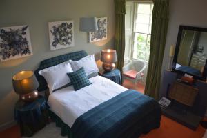 a bedroom with a large bed and a mirror at Scaurbridge House in Thornhill