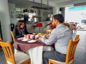 a man and woman sitting at a table eating food at Libertad Hotel in Trujillo