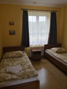a bedroom with two beds and a window at POD ORŁEM in Wałcz
