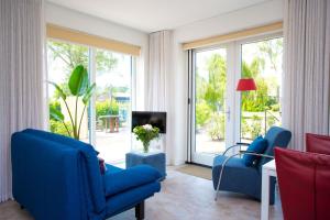 ein Wohnzimmer mit 2 blauen Stühlen und einem TV in der Unterkunft Domein Groot Besselink | Studio in Almen