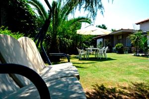 a bench in a yard with a table and an umbrella at Garden House in Velika