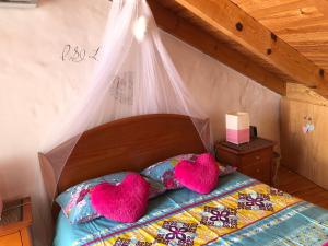 a bedroom with a bed with two heart pillows at Casinha Teles in Alvor