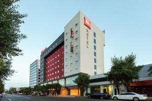 a tall building with a sign on top of it at Ibis Mexico Tlalnepantla in Mexico City