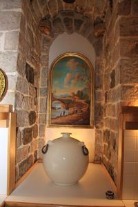 a large white vase sitting in a room with a painting at Hotel Morlacchi in Perugia