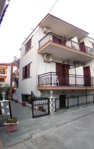 a white building with a balcony and a fence at Villa Anastasia in Limenas
