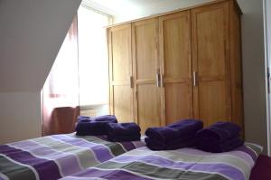 ヴェスターラントにあるFerienwohnung Paulinaのベッドルーム1室(紫色の枕が付いたベッド1台付)