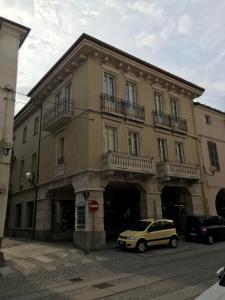 un edificio amarillo con un coche aparcado delante de él en Loft Acaja en Fossano