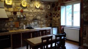 a kitchen with a table and a stone wall at Casale delle ginestre. in Castel Madama