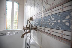 La salle de bains est pourvue d'une baignoire avec un tuyau. dans l'établissement Hôtel Terminus, à Cahors