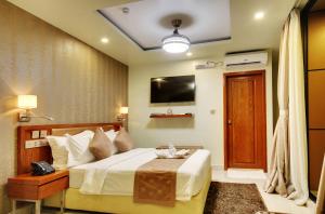a bedroom with a bed and a television at Unima Grand in Male City
