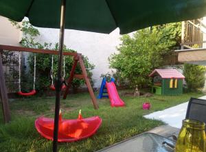 a playground with a swing set and an umbrella at Villa Anastasia in Limenas