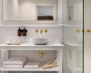 a white bathroom with a sink and a mirror at Alta House Begur in Begur