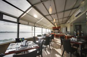 un ristorante con tavoli, sedie e ampie finestre di Unima Grand a Città di Malé
