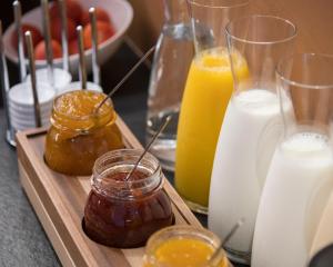a tray with jars of honey and bottles of milk at Alta House Begur in Begur