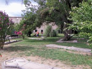 a person walking in a yard with trees and flowers at Les mobil-homes du Moulinage in Montréal