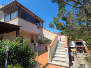 a house with stairs leading up to it at La Vela Apartment in Stintino