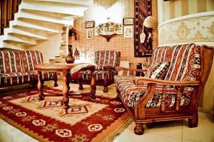sala de estar con 2 sillas y mesa en David Hotel - Ethno style, en Tiflis