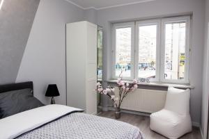 ein Schlafzimmer mit einem Bett, einem Fenster und einem Stuhl in der Unterkunft Novel in Warschau