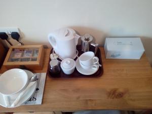 a tray with cups and dishes on a table at Homestay, Number 29, Dunollie in Oban