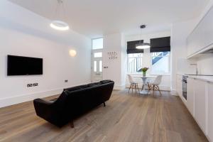 a living room with a couch and a table at Veeve - Contemporary Studio in Swiss Cottage in London