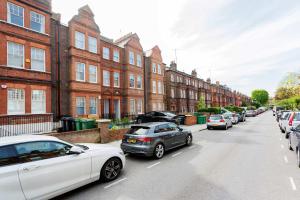 a row of cars parked on a street with buildings at Veeve - Contemporary Studio in Swiss Cottage in London