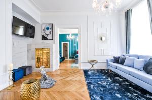 a living room with a blue couch and a fireplace at Glamour Frida apartment in Prague