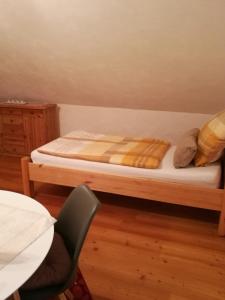 a bed in a room with a table and a chair at Ferienwohnung Edda in Ebensfeld