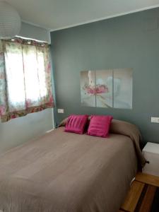 a bedroom with a large bed with pink pillows at Apartamento en la Ciudad de las Artes y las Ciencias in Valencia