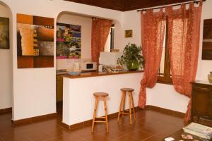 a kitchen with two stools and a counter with a microwave at B&B Vecchia Alghero in Alghero