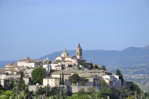 een dorp bovenop een heuvel met een kerk bij Casa Francesconi in Pietra Rossa