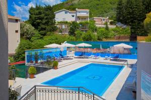 a large swimming pool with chairs and umbrellas at Apartments Jovan in Sveti Stefan