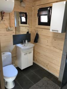 a bathroom with a white toilet and a sink at Domki na Morskiej in Łukęcin