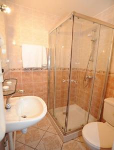 La salle de bains est pourvue d'une douche, d'un lavabo et de toilettes. dans l'établissement Sully Hôtel, à Paris