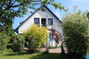 青斯特的住宿－Ferienwohnung Kranichblick，蓝色屋顶的白色房子