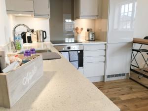 a kitchen with white cabinets and a counter top at No 3 Old Printworks in Winchester