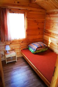 a room with a bed in a log cabin at Domki Letniskowe ,,Tęcza" in Rusinowo
