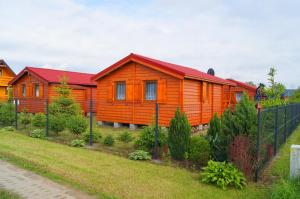 a row of orange cabins in a yard at Domki Letniskowe ,,Tęcza" in Rusinowo