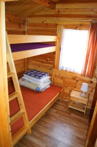 a bedroom with bunk beds in a log cabin at Domki Letniskowe ,,Tęcza" in Rusinowo