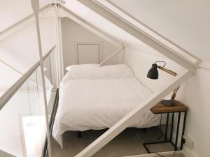 a bedroom with a white bed and a table at No 3 Old Printworks in Winchester